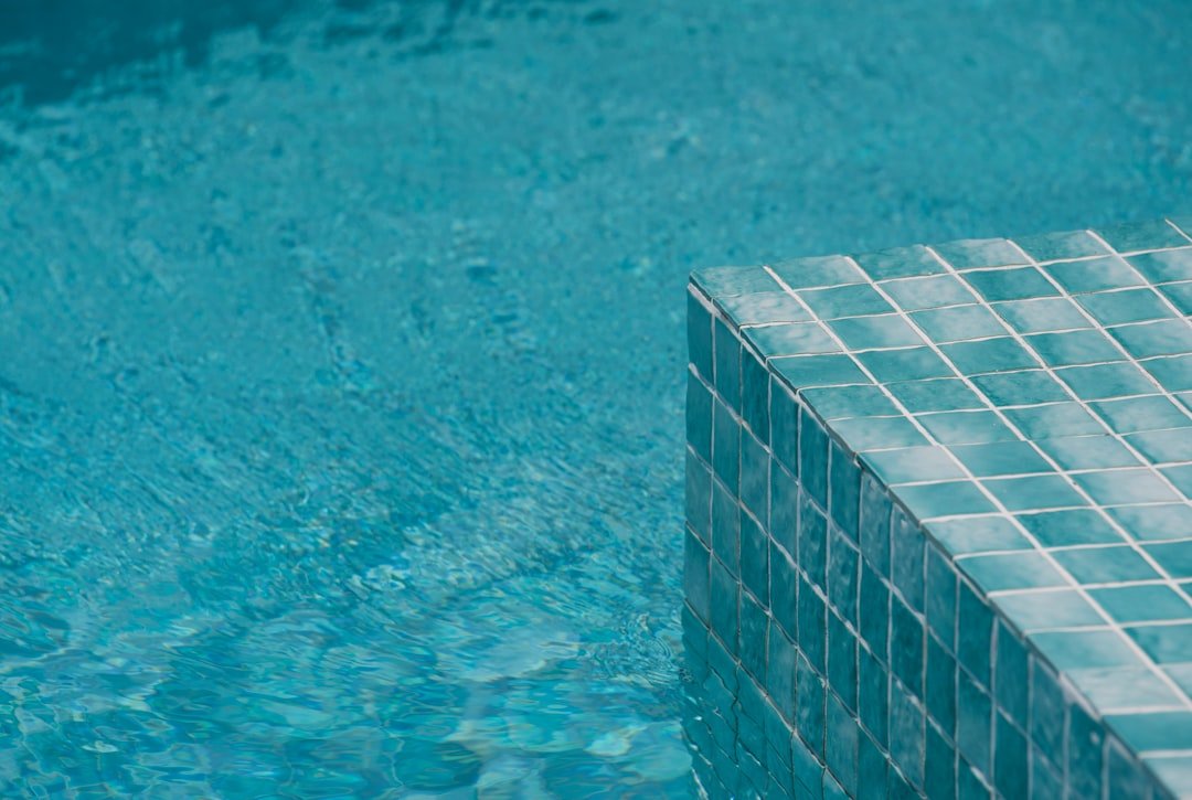 Crystal clear swimming pool with modern design and comfortable lounge chairs